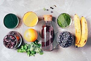 Blueberries, bilberry, barley grass, spirulina, orange juice, dulse, cilantro on marble background. Top view. Healthy eating,