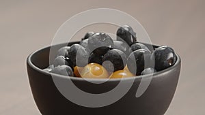 blueberries in black bowl with physalis closeup