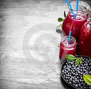 Blueberries and blueberry juice. On black wooden background.