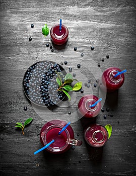 Blueberries and blueberry juice. On black wooden background.