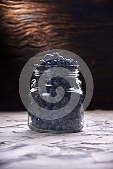 Blueberries fresh front view close up arrangement in glass jar on old white rustic wooden table