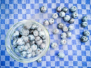 Blueberries in a jar on a checkered towel.