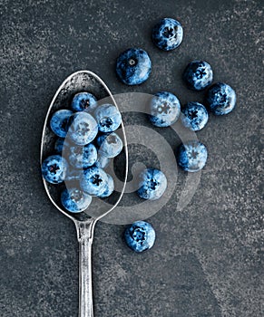 Blueberries laying in a vintage spoon with a patina.