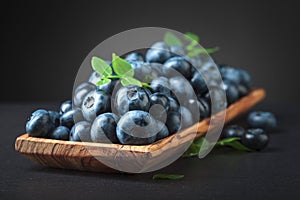 Blueberries with leaves in wooden dish