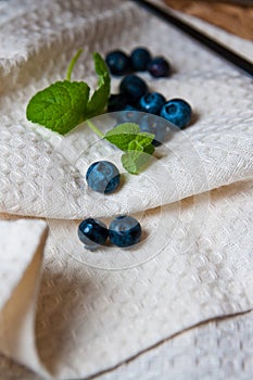Blueberries with mint leaves on linen