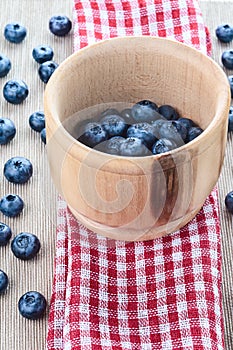 Blueberries in mortar on red towel