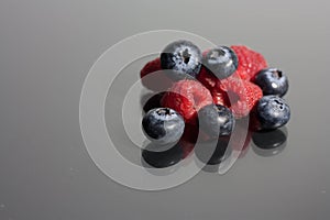 Blueberries and raspberries on black background