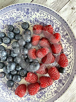 Blueberries and raspberries on a vintage plate