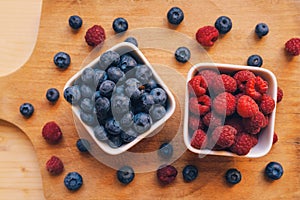 Blueberries and raspberries in white ceramic bowl