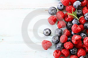 Blueberries and raspberries on wooden table