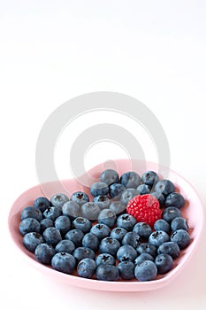 Blueberries and raspberry on the heart shaped plat