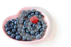 Blueberries and raspberry on the heart shaped plat