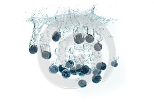 Blueberries falling into water on white background