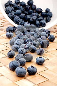 Blueberries spilling from a bowl onto a placemat