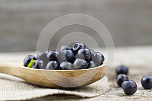 Blueberries in spoon on wooden background, close-up