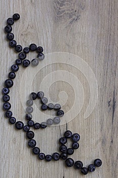 Blueberries on wooden background; Healthy heart symbol