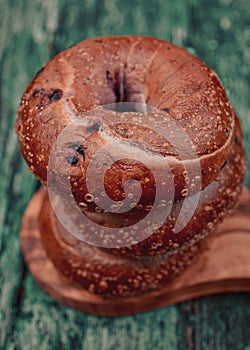 Blueberry bagel on top of stack of three bagels
