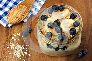 Blueberry and banana breakfast overnight oatmeal in mason jar photo