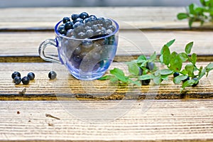 Blueberry berries lie in a cup on a table in the kitchen