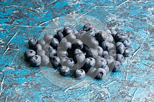 Blueberry berry on table close up macro, blue concrete background with copy space