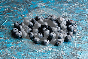 Blueberry berry on table close up macro, blue concrete background with copy space