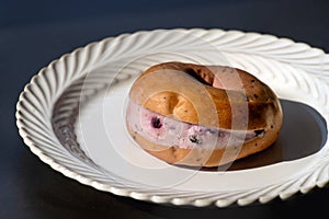 Blueberry cheese bagel on white plate