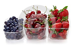 Blueberry, cherry and strawberry in plastic container box isolated on white