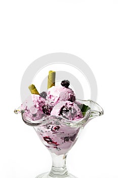 Blueberry ice cream with fresh fruits in a glass cup isolated on white