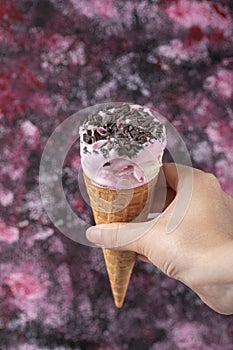 Blueberry icecream with chocolate chips in the waffle cone