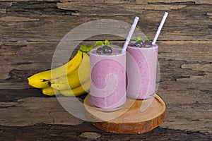 Blueberry Juice and Banana smoothies, a tasty healthy drink in a glass, drink the morning on a wooden background.