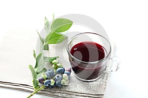 Blueberry juice with raw fruit and tea cup on white background