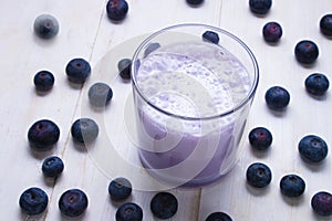 Blueberry milkshake in a glass and some fruits