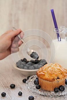 Blueberry Muffin Breakfast With Milk And Hand Spooning Blueberries