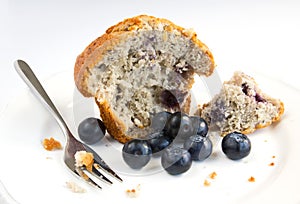 Blueberry muffin with fresh fruit on white plate