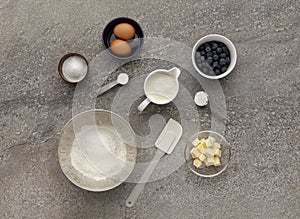 Blueberry muffin ingredient mixture, on a stone work surface.