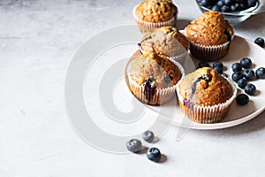 Blueberry muffins served in a plate on a marble background. Copy space