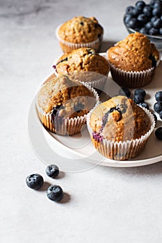 Blueberry muffins  served on a white plate on a marble background