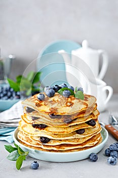 Blueberry pancakes with butter, maple syrup and fresh berries. American breakfast