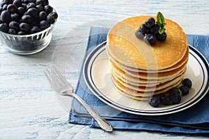 Blueberry pancakes on a plate with a fork