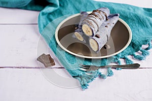 Blueberry pancakes stuffed with whole banana wrapped in a tube and poured with chocolate