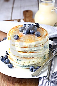 Blueberry pancakes with vanilla syrup on table