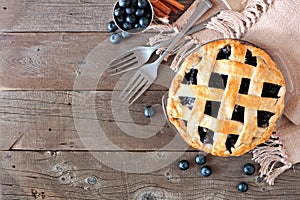 Blueberry pie, top view corner border over a rustic wood background