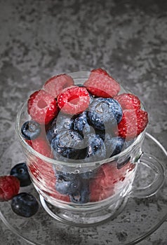 Blueberry and raspberry in a clay plate. Raw berries mix close up