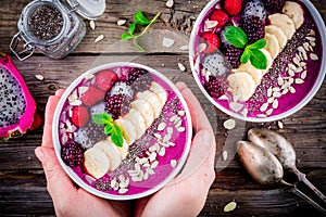 Blueberry smoothie bowl with banana, raspberry, pitaya, blackberry, almonds, sunflower and chia seeds