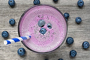 Blueberry smoothie or milkshake with chia seeds, fresh berries and stripped straw