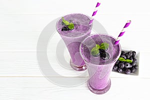 Blueberry smoothies, fruit juices and blueberries on a white wooden background. Drink in the morning for good health.