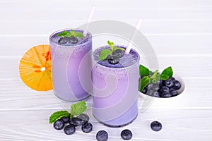 Blueberry smoothies fruit juices and blueberries on a white wooden backgroun. Drink in the morning for good health.