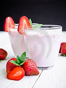 Blueberry smoothie with strawberry on wooden background. Fresh milkshake with berries