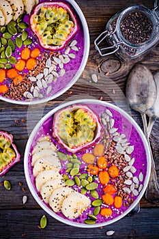 Blueberry smoothies bowl with sea-buckthorn, banana, passion fruit, chia seeds, pumpkin seeds, sunflower and flax seeds