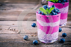 Blueberry smoothies with chia pudding in glasses with fresh berries and mint